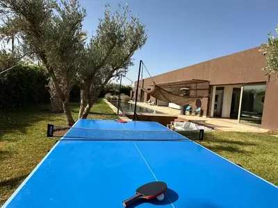 a ping pong table in the backyard of a house at Villa Zen'O Palmeraie - Hot Pool in Marrakech