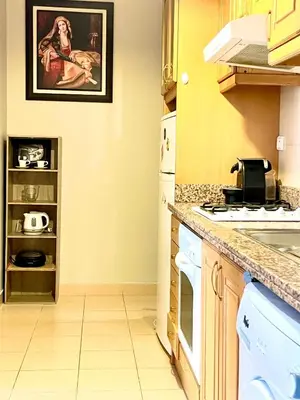 a kitchen with white appliances and a painting on the wall at Sunset Marrakech in Marrakech