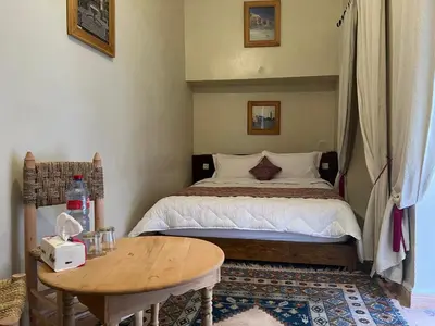 a small bedroom with a bed and a table at Riad Dar Les Freres in Marrakech