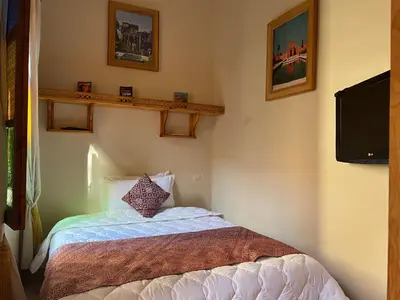 a small bedroom with a bed and a tv at Riad Dar Les Freres in Marrakech