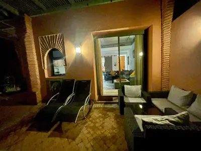 a living room with a couch and chairs and a mirror at Au Cœur de la Palmeraie de Marrakech in Marrakech