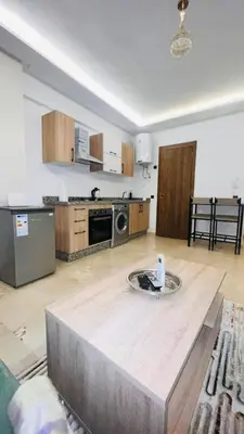 a kitchen with a table in the middle of a room at Luxury apartment Gueliz (2 min walk from Train Station) in Marrakech