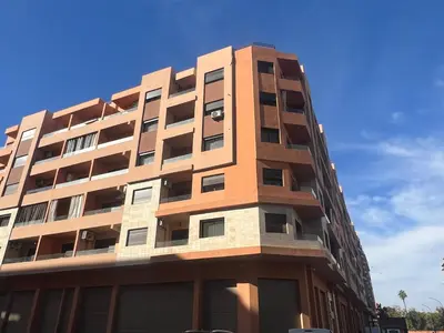 a tall apartment building with a blue sky in the background at Luxury apartment Gueliz (2 min walk from Train Station) in Marrakech