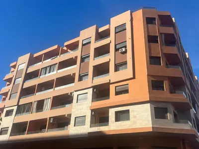 a tall apartment building against a blue sky at Luxury apartment Gueliz (2 min walk from Train Station) in Marrakech