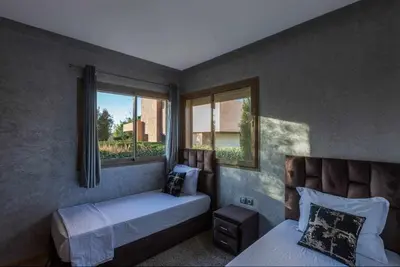 a bedroom with two beds and a window at Prestigia golf city porte agate in Marrakech
