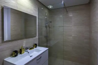 a bathroom with a sink and a glass shower at Prestigia golf city porte agate in Marrakech