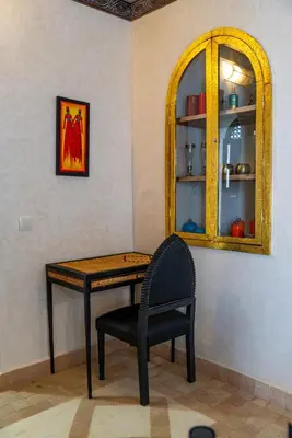 a table and a chair in a room with a mirror at Riad Nalan & Spa in Marrakech