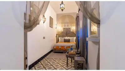 a bedroom with a bed and a table in a room at Riad 4 Jardins & Spa in Marrakech