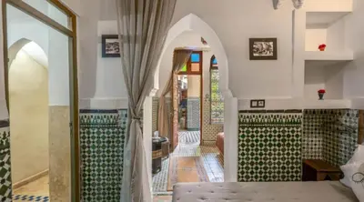 a bedroom with a bed and a hallway at Riad 4 Jardins & Spa in Marrakech