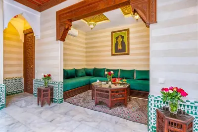 a living room with a green couch and tables at Riad Diamond Of Marrakech & Spa in Marrakech