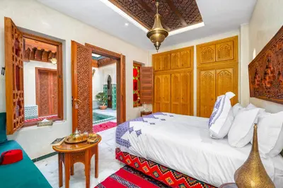 a bedroom with a bed and a table in a room at Riad Diamond Of Marrakech & Spa in Marrakech