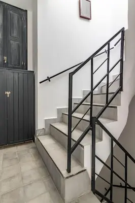 a set of stairs with a black railing next to a door at Maison Meurisse Marrakech in Marrakech