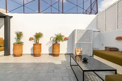 a living room with a table and potted plants at Maison Meurisse Marrakech in Marrakech