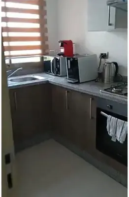 a kitchen with a counter top with a stove and appliances at Prestigia jade Marrakech ENTREE 191 APPARTEMENT 9 in Marrakech