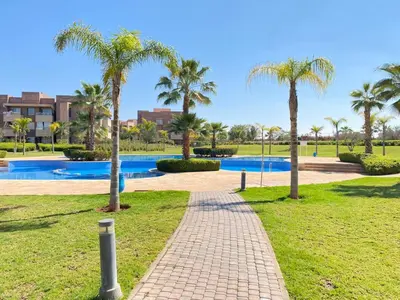 a brick path in a park with palm trees at Prestigia jade Marrakech ENTREE 191 APPARTEMENT 9 in Marrakech