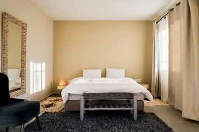 a bedroom with a bed and a chair and a mirror at Dar Meha in Marrakech