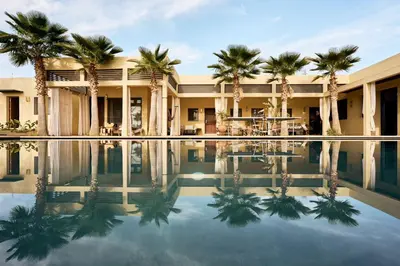 a hotel with palm trees and a swimming pool at Dar Meha in Marrakech
