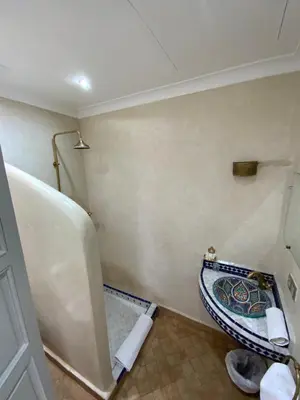 a small bathroom with a tub and a sink at Riad privatisé Magnolia in Marrakech