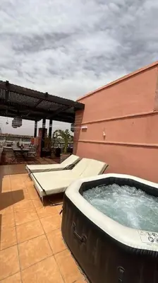 a hot tub sitting on a patio next to a building at Magnifique villa avec piscine chauffée in Marrakech