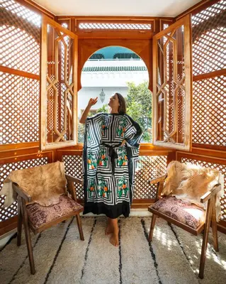 a woman standing in a room looking out a window at Riad Botanica in Marrakech