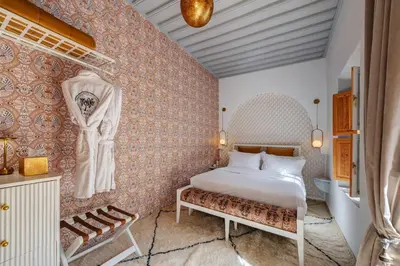 a bedroom with a bed and a bench in a room at Riad Botanica in Marrakech