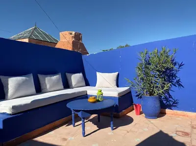 a blue couch and a table on a patio at Jolie petit Riyad avec piscine belle terrasse wifi in Marrakech