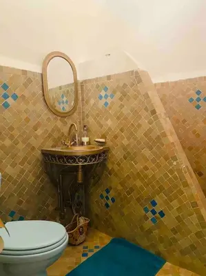 a bathroom with a toilet and a sink at Jolie petit Riyad avec piscine belle terrasse wifi in Marrakech