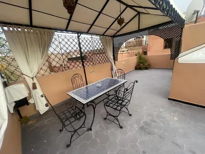 a patio with a table and chairs on a balcony at Dar Chrif in Marrakech