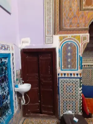 a bathroom with a sink and a door and tiles at Maison authentique centre médina in Marrakech