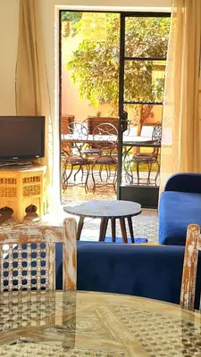 a living room with a blue couch and a table at Villa Kalthoum in Marrakech