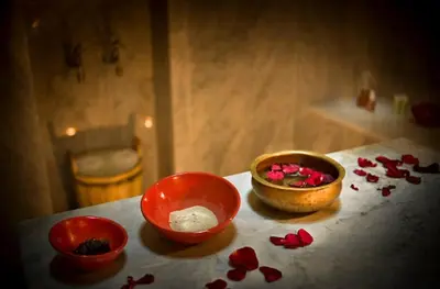 three bowls on a table with red rose petals at Riad Espoir Spa Logement entier in Marrakech