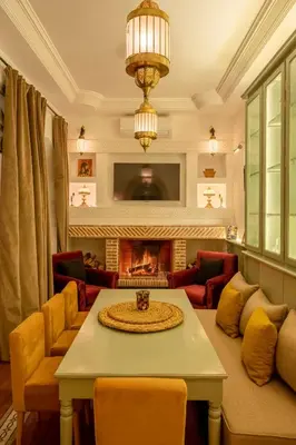 a living room with a table and a fireplace at Riad Espoir Spa Logement entier in Marrakech