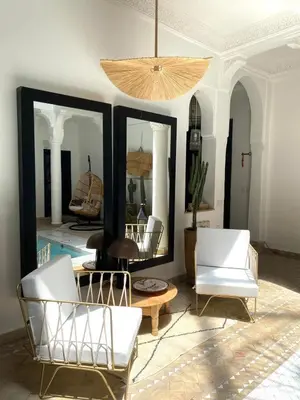 a living room with two mirrors and white chairs at RIAD DAR C in Marrakech