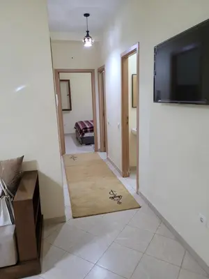 a hallway with a flat screen tv and a living room at Basic appartement avec Parking in Marrakech