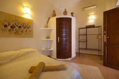 a bedroom with a bed and a wooden door at Riad Noor Charana in Marrakech