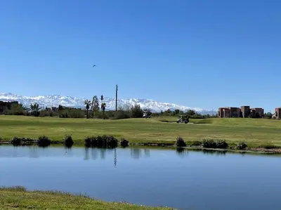 a view of a golf course with a pond at Appartement de luxe Prestigia Opale in Marrakech