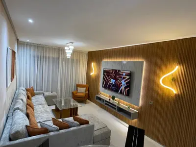 a living room with a couch and a tv on a wall at Appartement de luxe Prestigia Opale in Marrakech