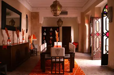 a dining room with a table and chairs and stained glass windows at Riad Sassa Finda in Marrakech