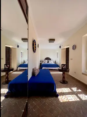 two beds in a room with blue sheets at Riad Sassa Finda in Marrakech