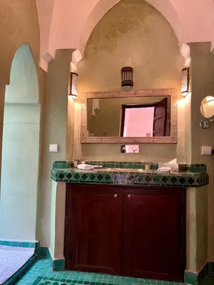 a bathroom with a vanity and a mirror at Riad Sassa Finda in Marrakech