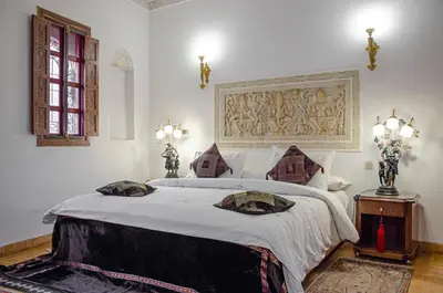 a bedroom with a large bed with white sheets at Riad Esmeralda in Marrakech