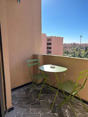 a table and two chairs sitting on a balcony at Super appartement au cœur de Marrakech in Marrakech