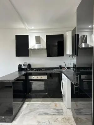 a large kitchen with a stove and a sink at Super appartement au cœur de Marrakech in Marrakech