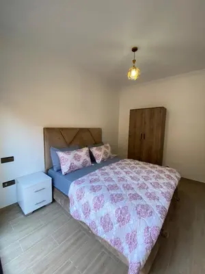 a bedroom with a bed and a night stand at Appartement de luxe Marrakech Gueliz in Marrakech
