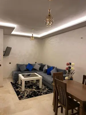 a living room with a blue couch and a table at Appartement de luxe Marrakech Gueliz in Marrakech