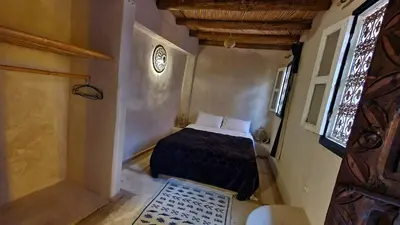a small bedroom with a bed and a window at Beldi Riad in Marrakech