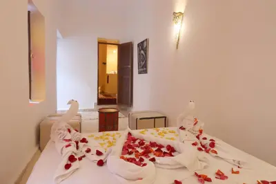 a bedroom with a bed with flowers on it at Riad Jenan L'mouassine in Marrakech