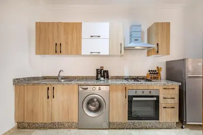 a kitchen with a sink and a washing machine at Chic & Cosy Appart au Centre Ville - 100 % Équipé in Marrakech