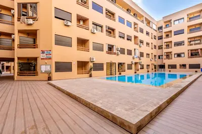an apartment building with a swimming pool in front of it at Chic & Cosy Appart au Centre Ville - 100 % Équipé in Marrakech