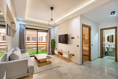 a living room with a couch and a table at Jolie & Luxueux Appart a Gueliz - 100% Équipé in Marrakech
